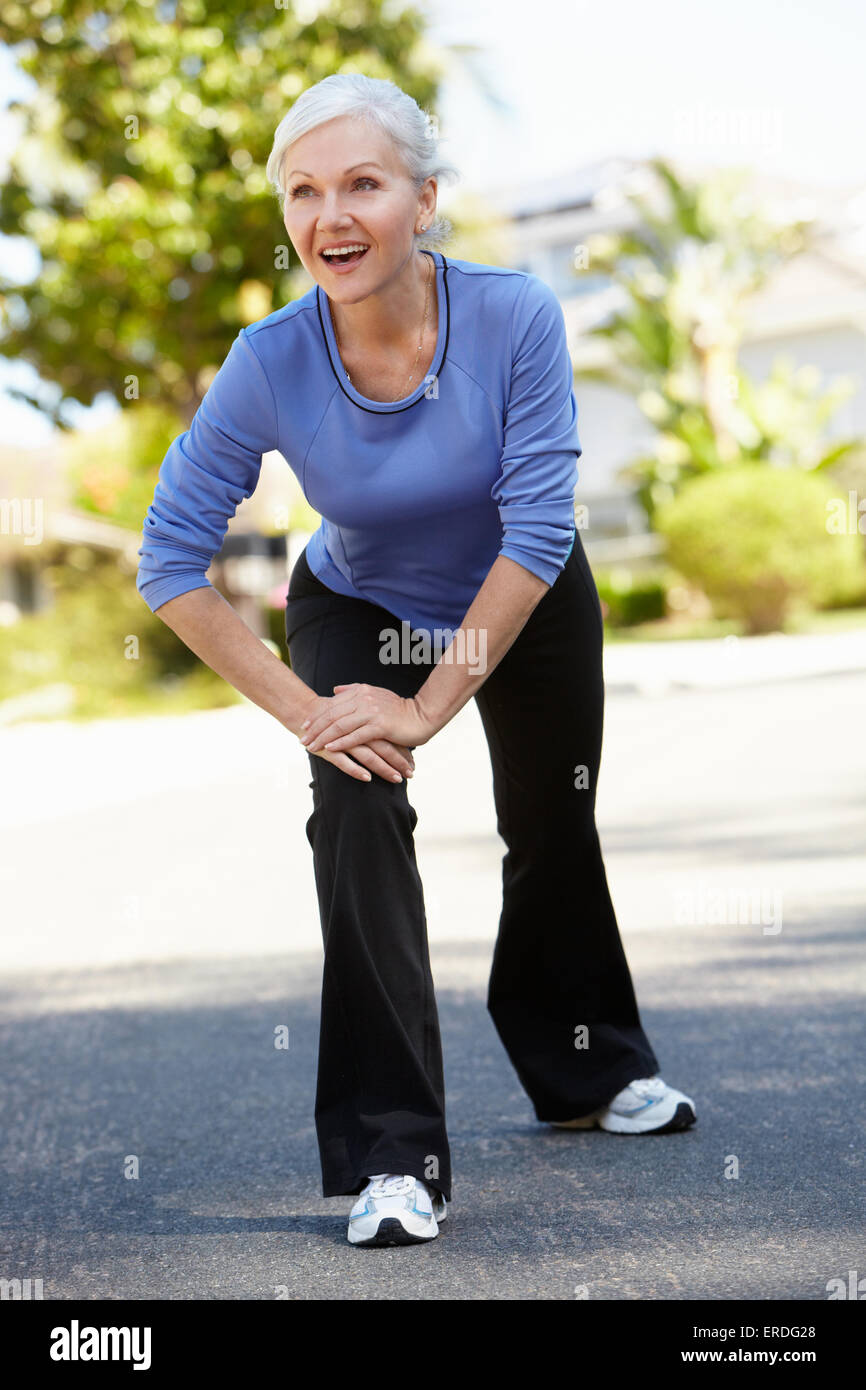 Mid age woman warming up for run Stock Photo