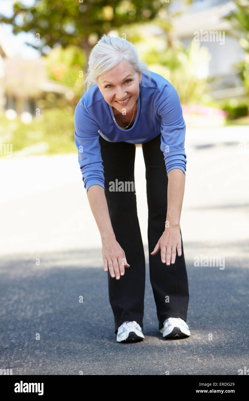 Mid age woman warming up for run Stock Photo