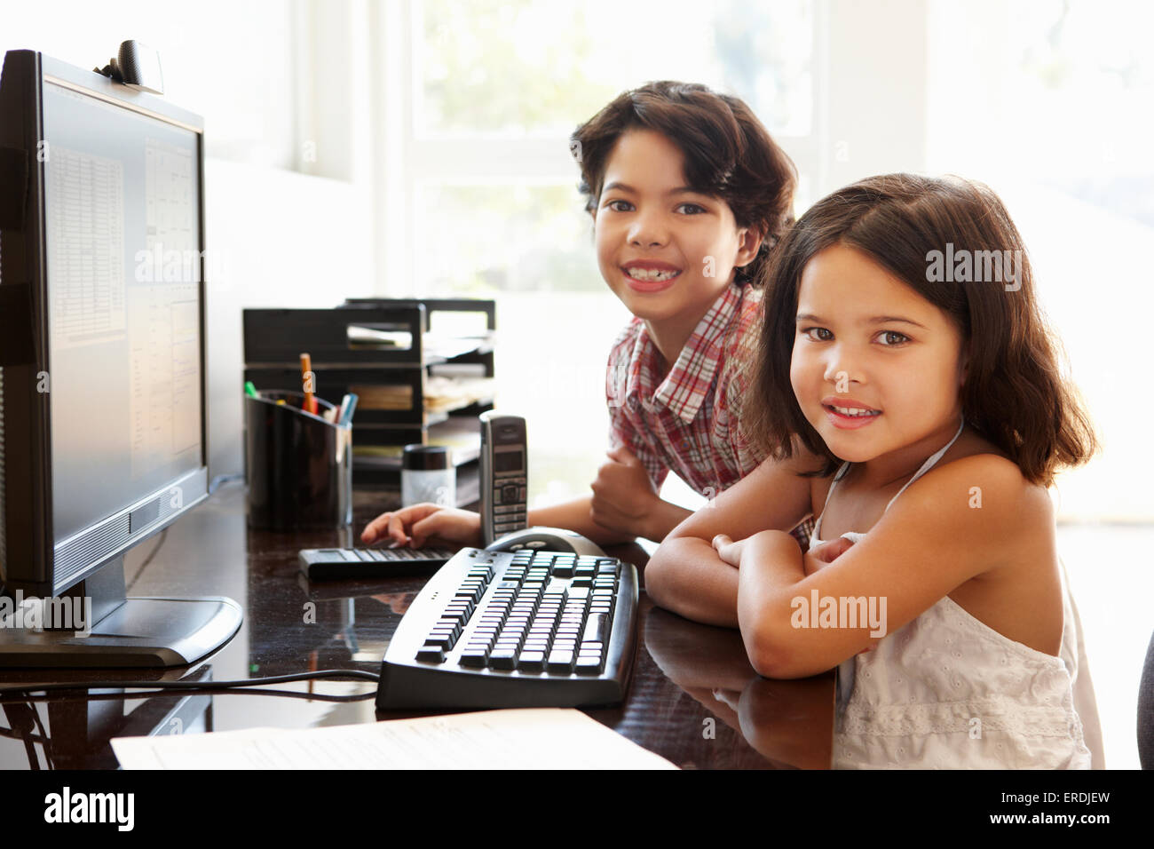 Hispanic children using computer at home Stock Photo