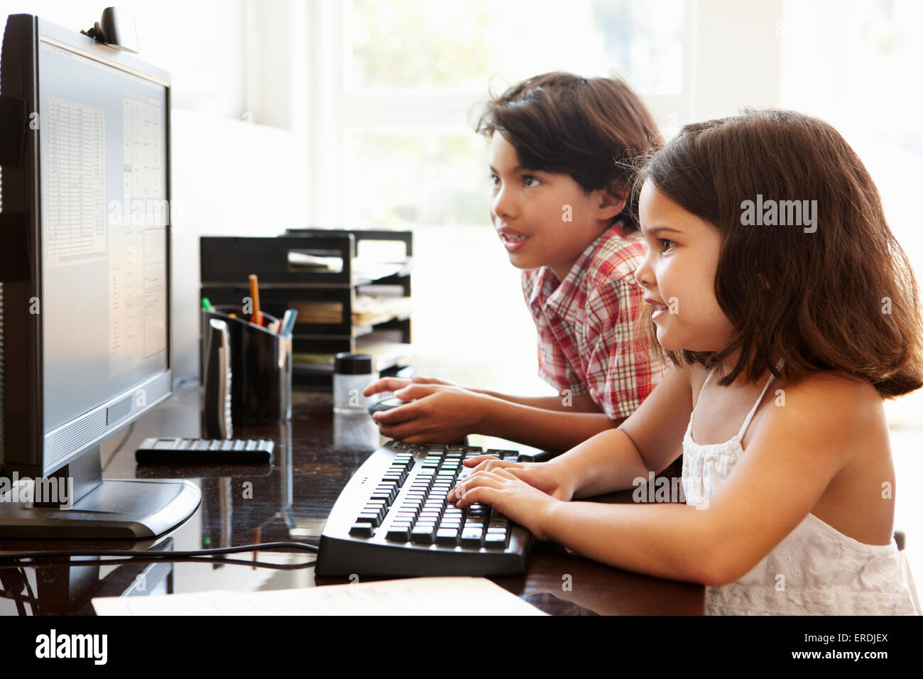 Hispanic children using computer at home Stock Photo
