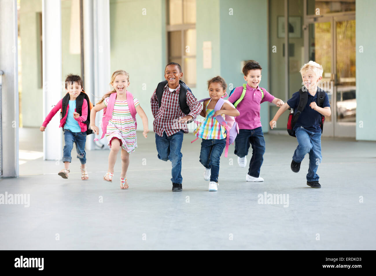 Group Of Elementary Age Schoolchildren Running Outside Stock Photo - Alamy