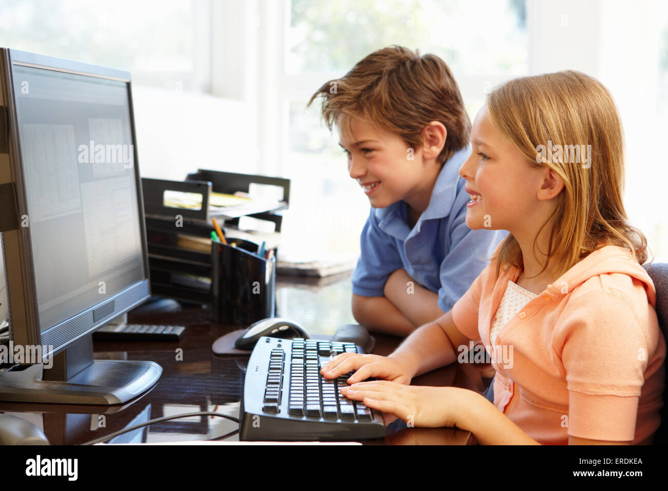 Young boy and girl using computer at home Stock Photo - Alamy