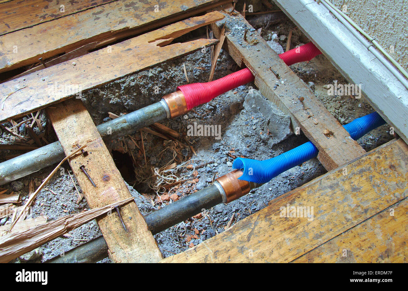 Cold and hot water pipes under a broken wood floor Stock Photo Alamy