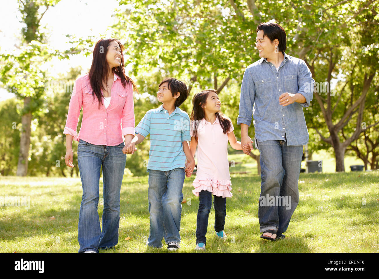 Asian family walking hand in hand in park Stock Photo