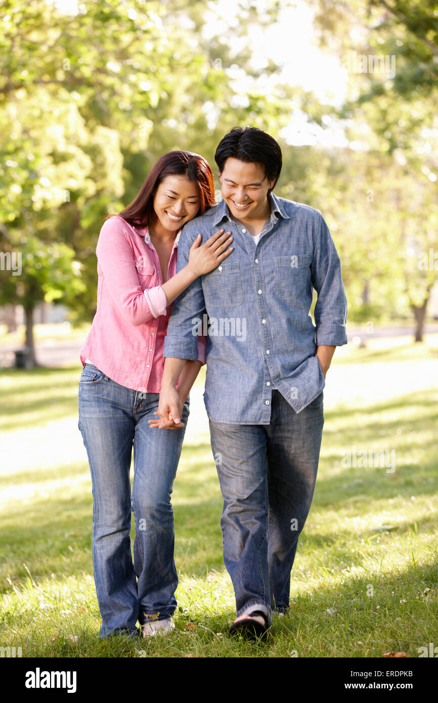 Asian couple walking hand in hand in park Stock Photo - Alamy