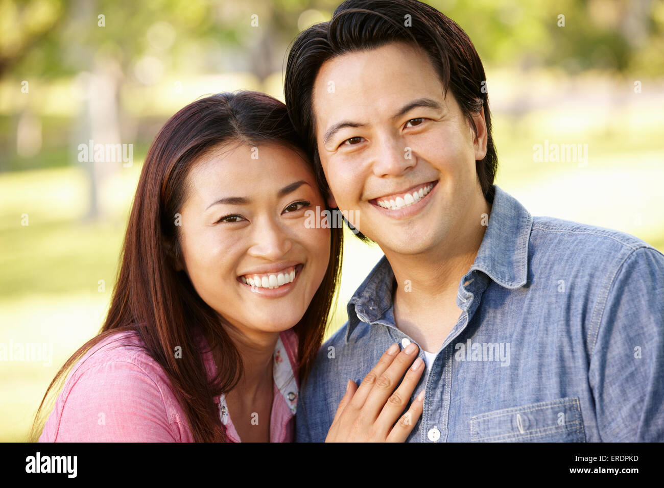Asian couple head and shoulders portrait outdoors Stock Photo - Alamy