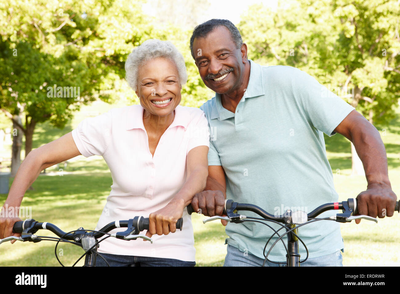 Senior African American Couple Cycling In Park Stock Photo - Alamy