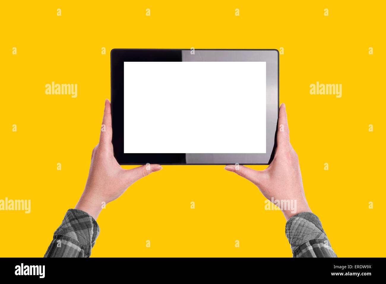 Woman Holding Ten Inch Digital Tablet Computer in Horizontal Position with Blank White Screen as Copy Space over Solid Yellow Ba Stock Photo