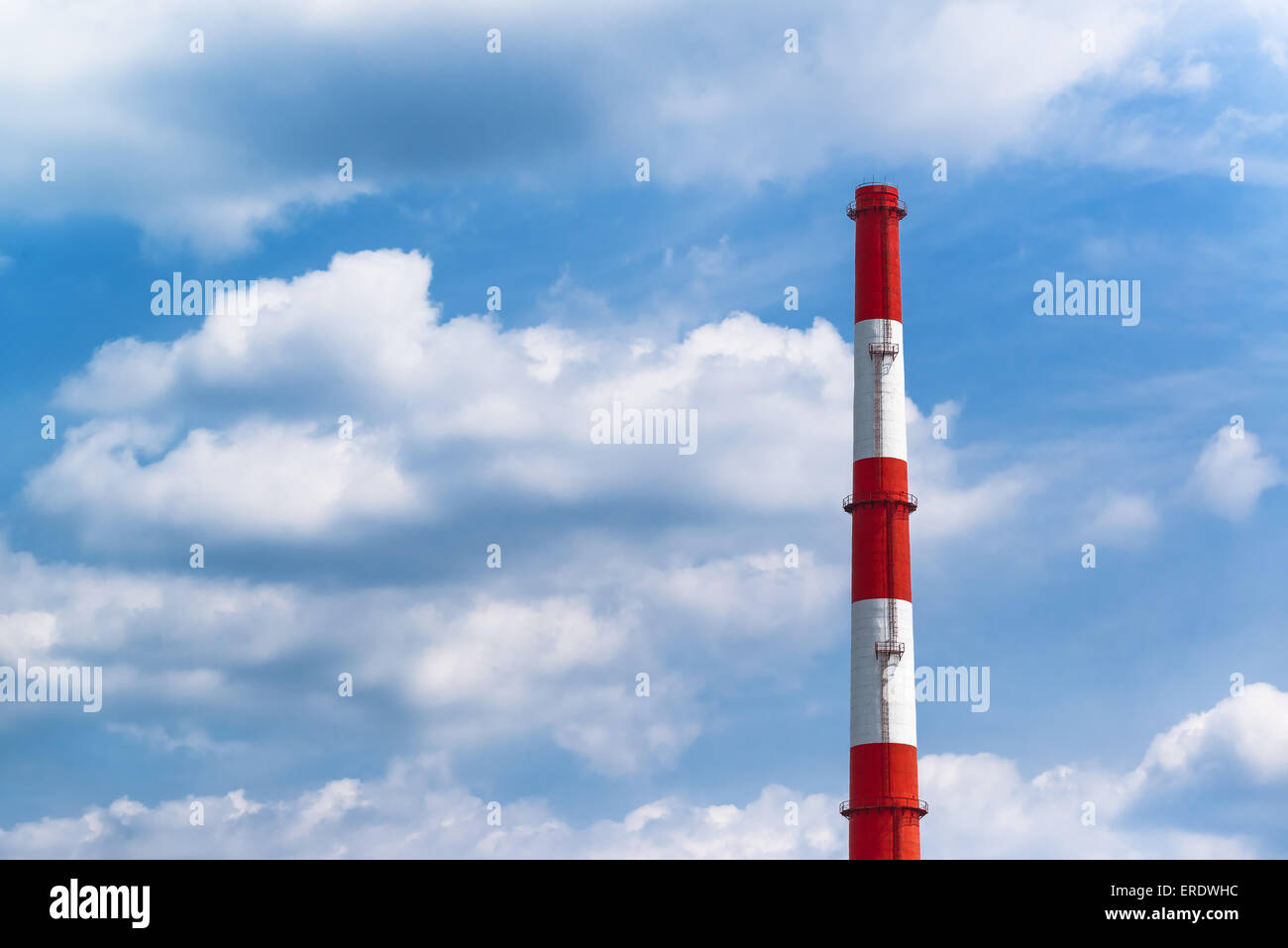 Red and White Power Plant Industrial Chimney Pipe against Blue Cloudy Sky Stock Photo