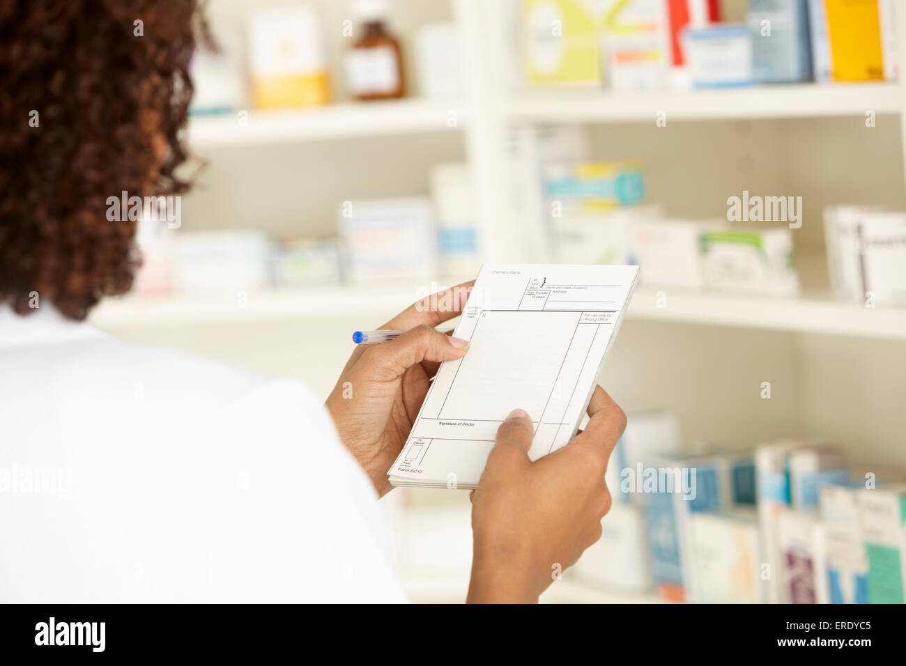 UK Female nurse in pharmacy with prescription Stock Photo