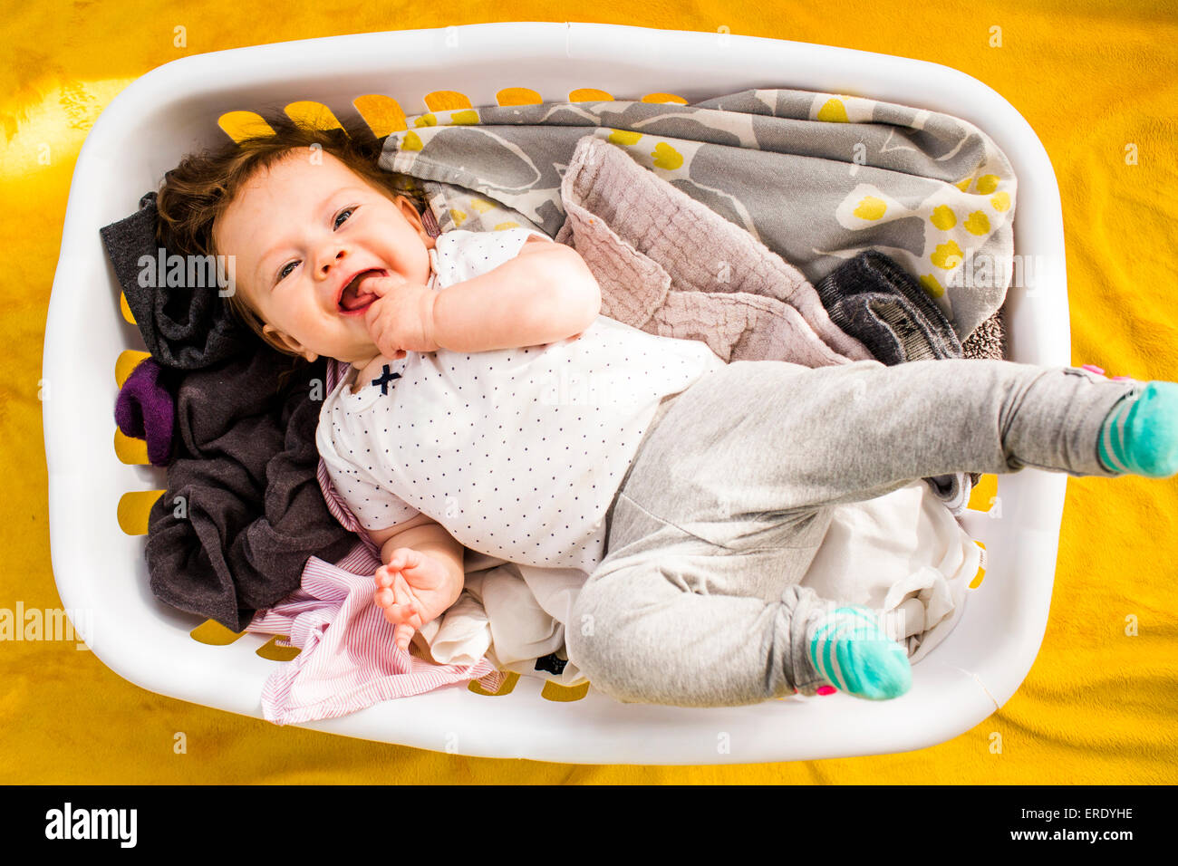 Caucasian baby girl laying in laundry basket Stock Photo