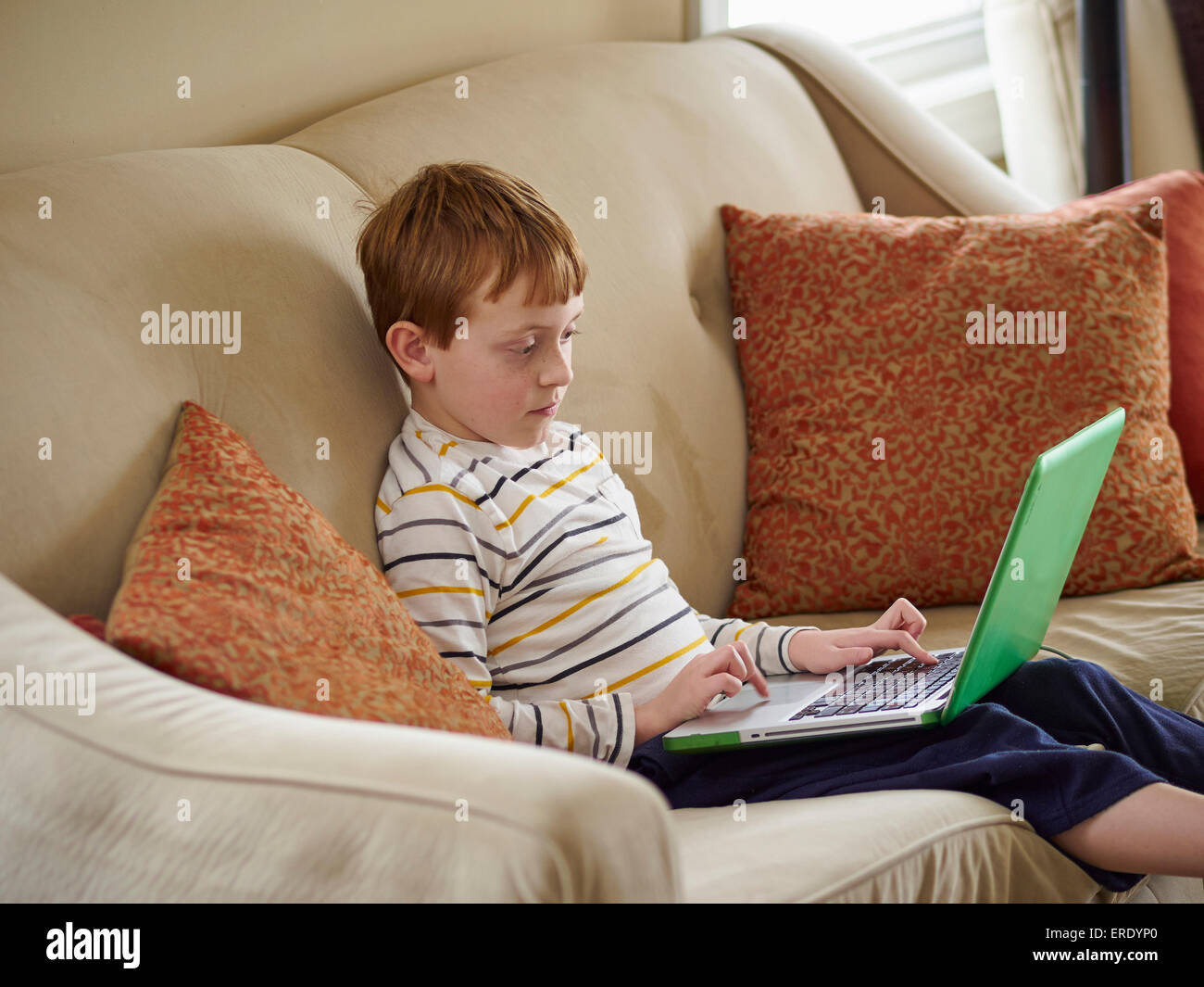 Caucasian boy using laptop on sofa Stock Photo - Alamy