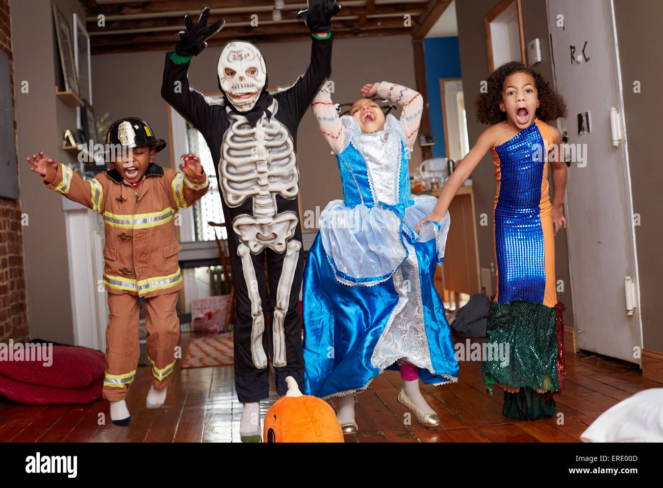 Children in Halloween costumes jumping for joy Stock Photo