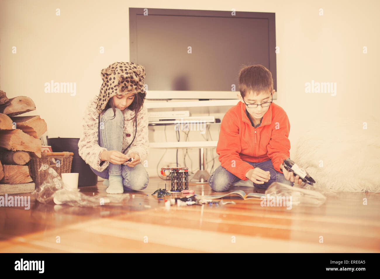 Mixed race brother and sister playing on living room floor Stock Photo