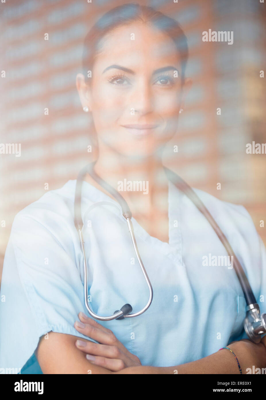 Caucasian doctor standing with arms crossed at window Stock Photo