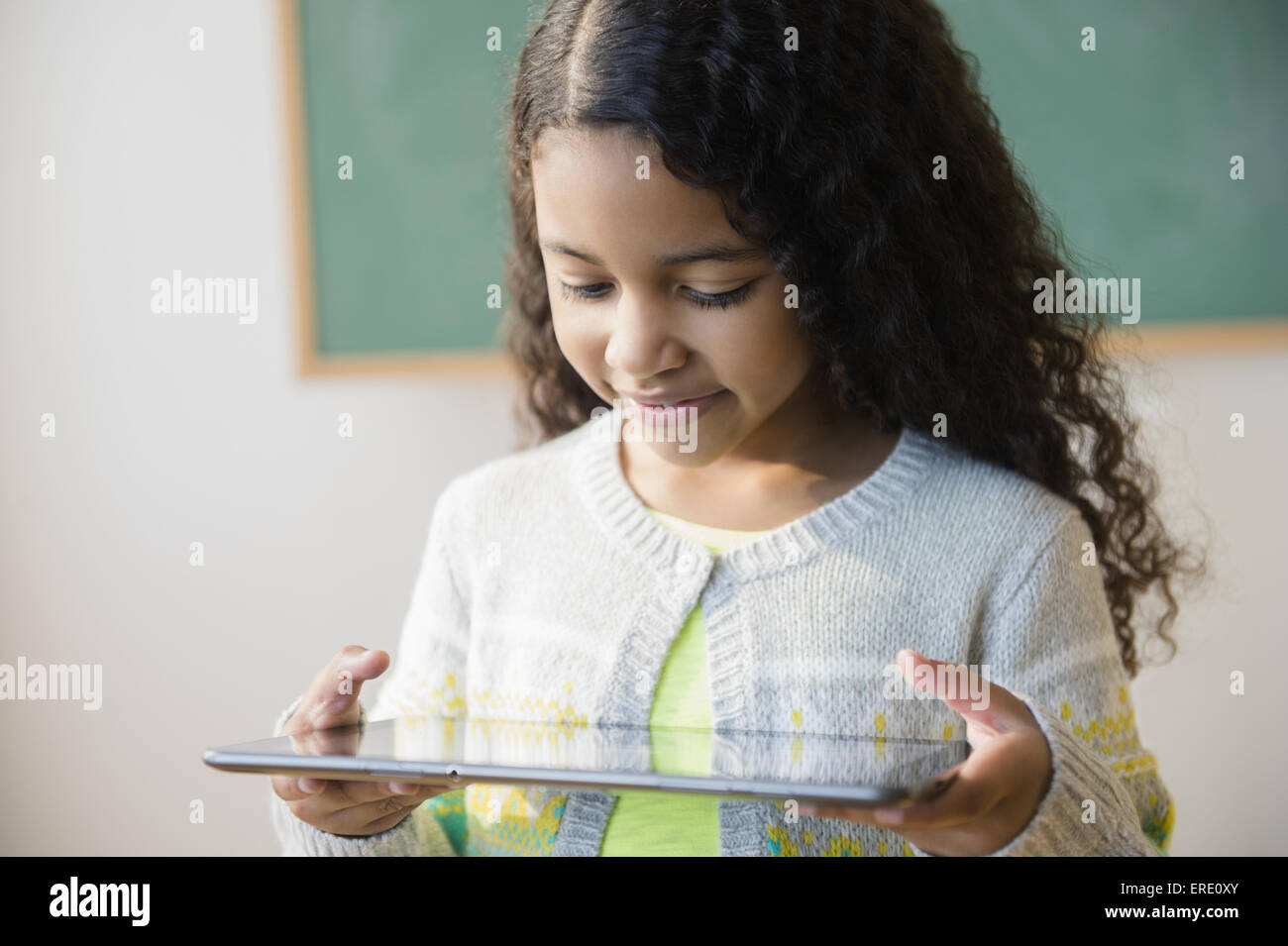 Mixed race student using digital tablet in classroom Stock Photo