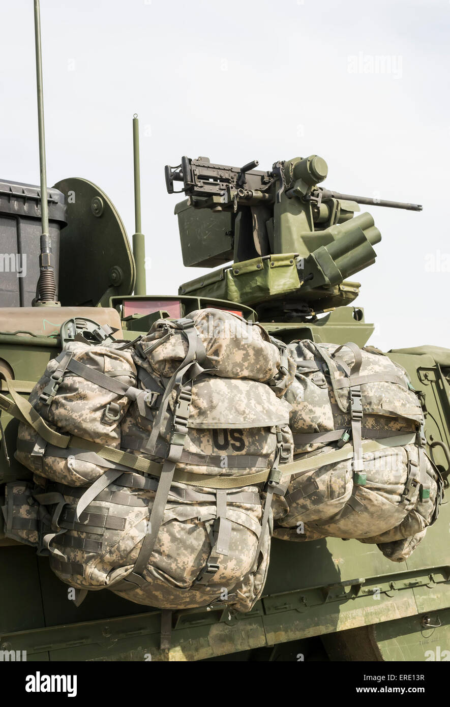 Two rucksacks currently belonging to U.S. army personnel attached to the side of an armored field vehicle Stock Photo