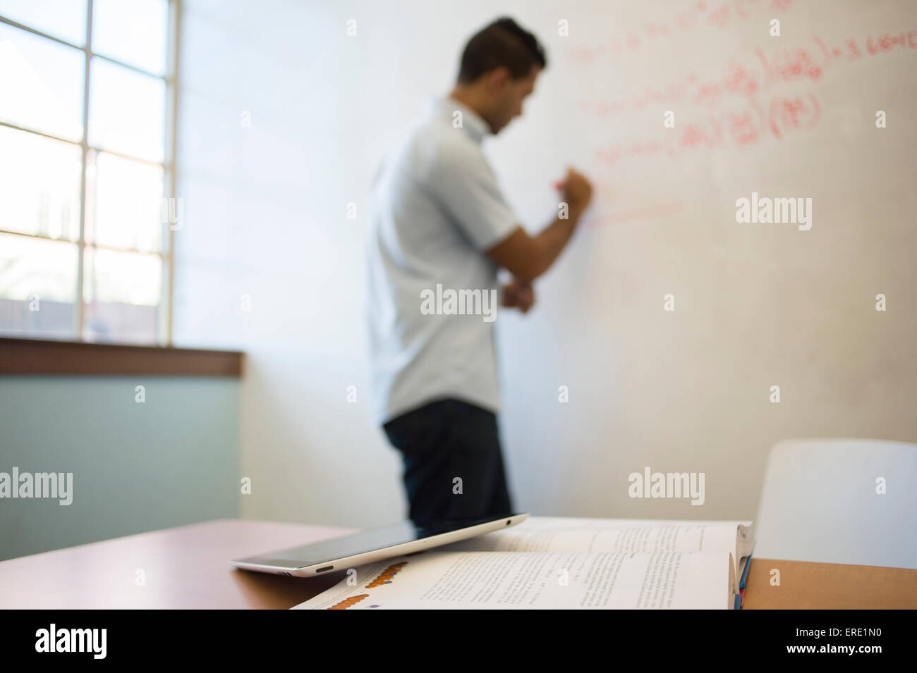 Asian businessman writing on whiteboard Stock Photo