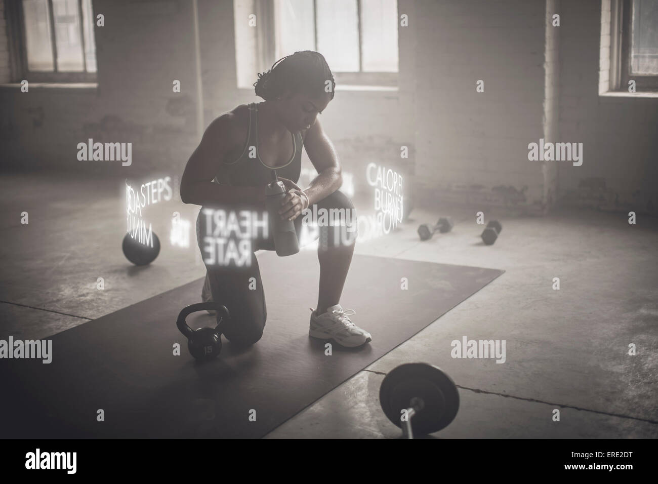 Virtual words circling Black athlete checking fitness tracker Stock Photo