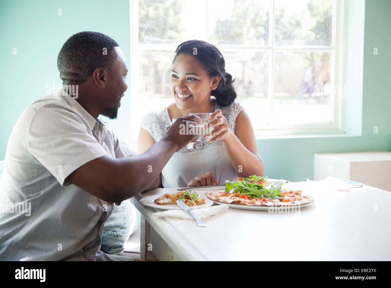 Smiling couple toasting at table Stock Photo