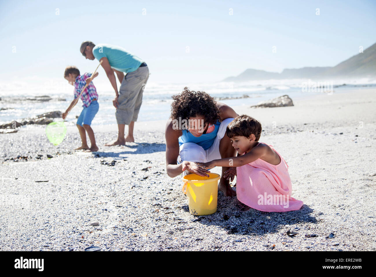 Mixed race family playing on beach Stock Photo Alamy