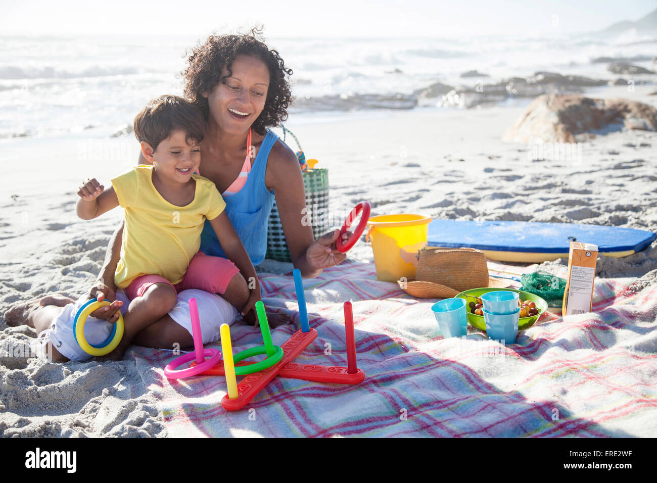 Mixed race mother and daughter playing at beach Stock Photo