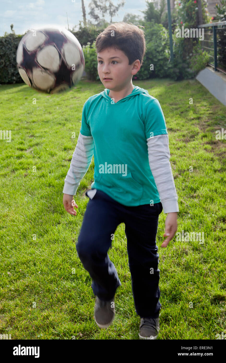 Hispanic boy juggling soccer ball in backyard Stock Photo Alamy