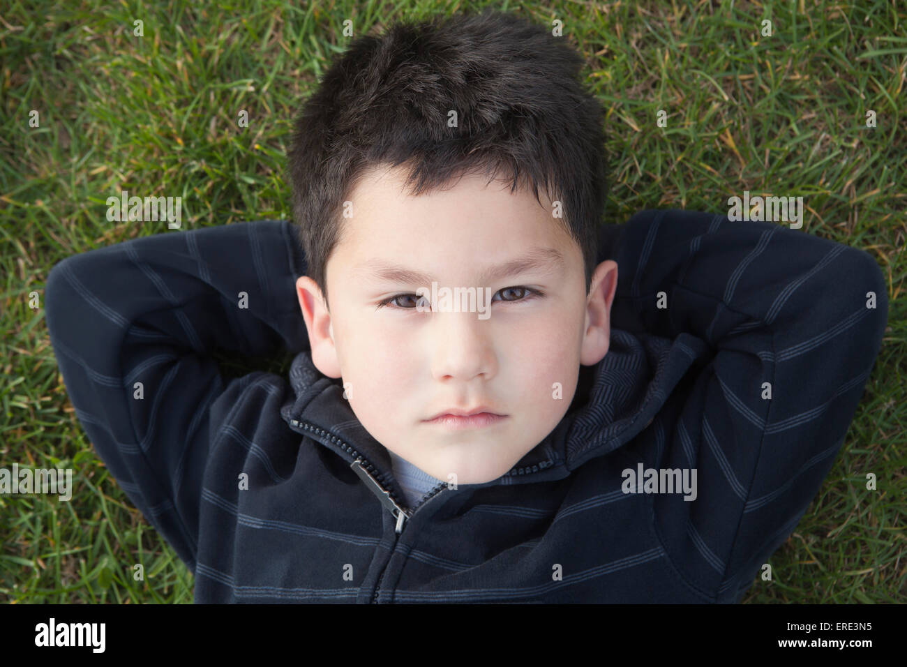 Hispanic boy laying in grass Stock Photo - Alamy