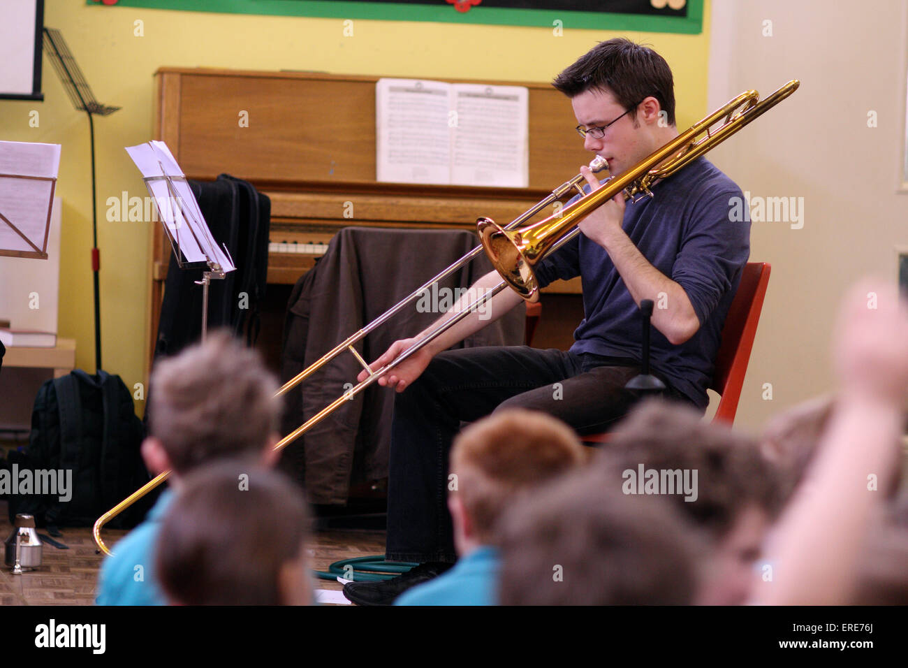 Trombone player demonstrating and teaching children in a school. Stock Photo