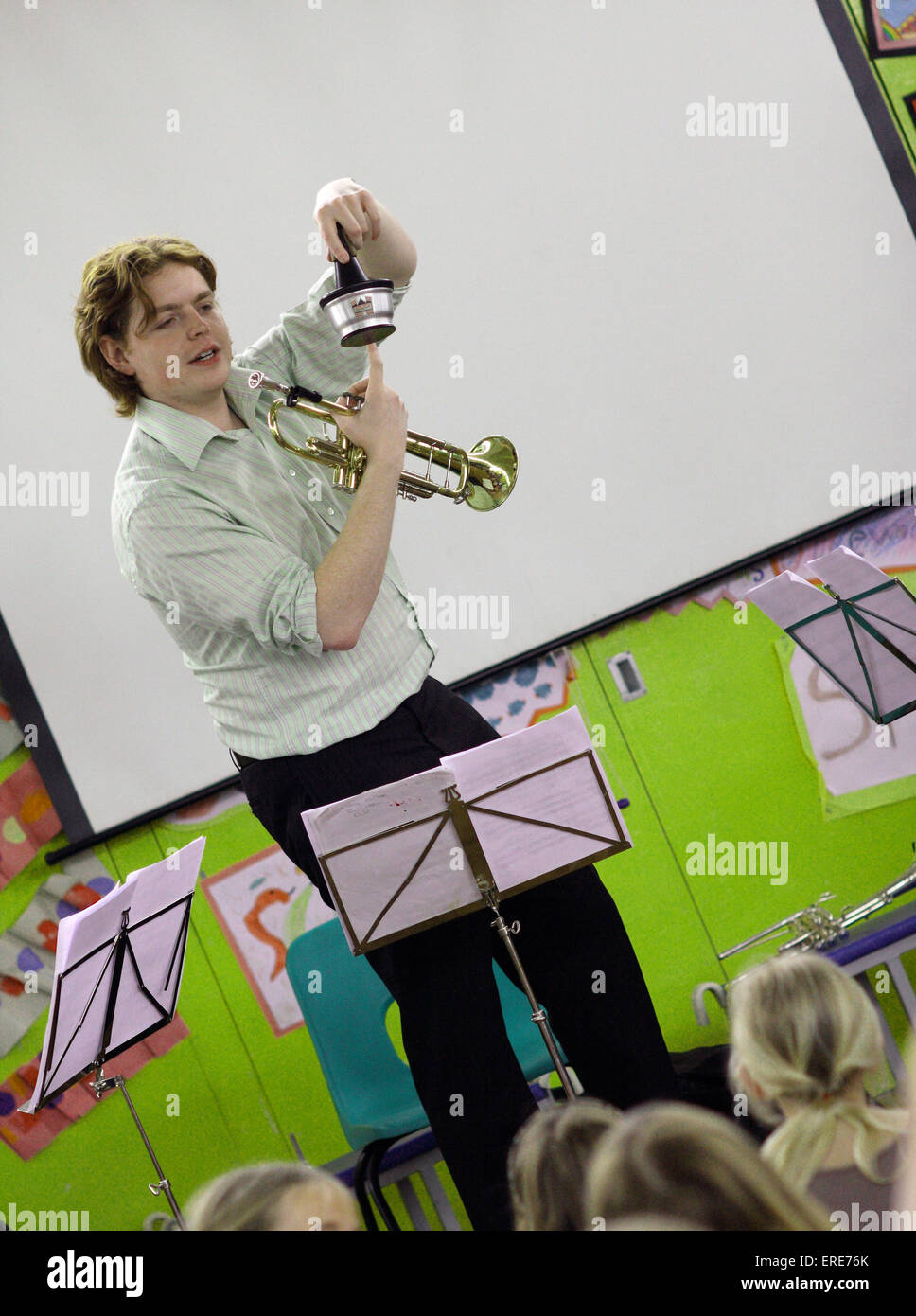 Trumpet teacher demonstrating how the trumpet and its mute work in a ...