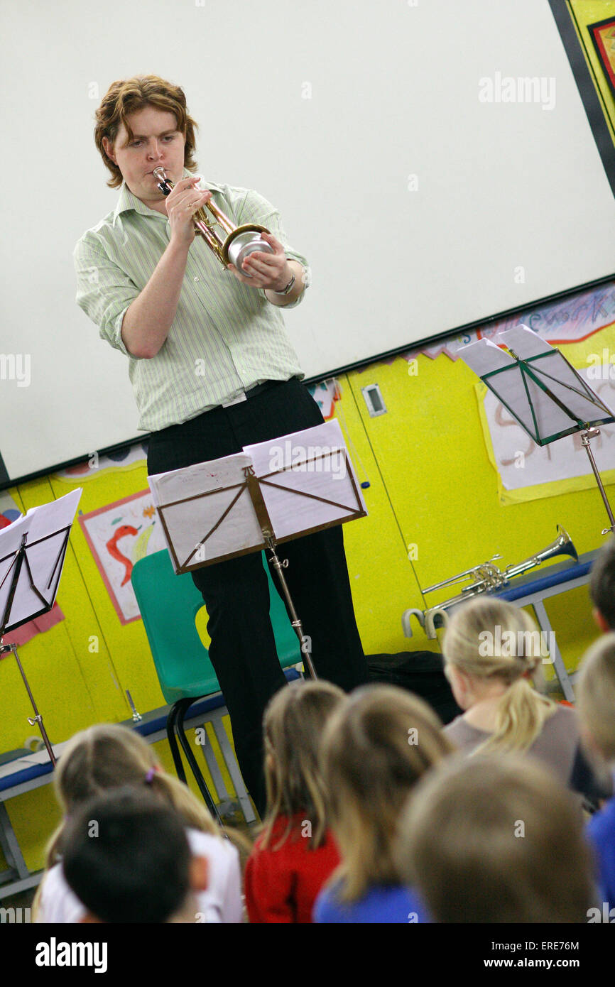 Trumpet teacher demonstrating how the trumpet and its mute work in a ...