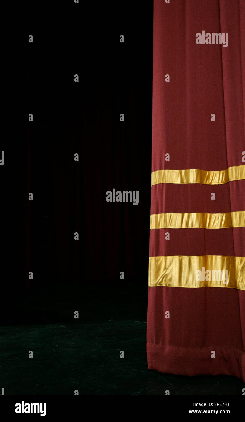 Single Red stage curtain with gold stripes, partly open Stock Photo