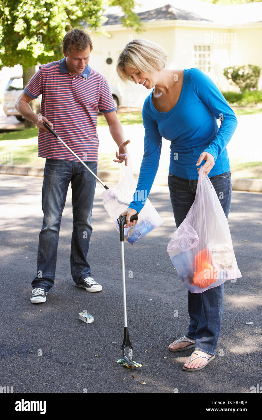Couple Picking Up Litter In Suburban Street Stock Photo
