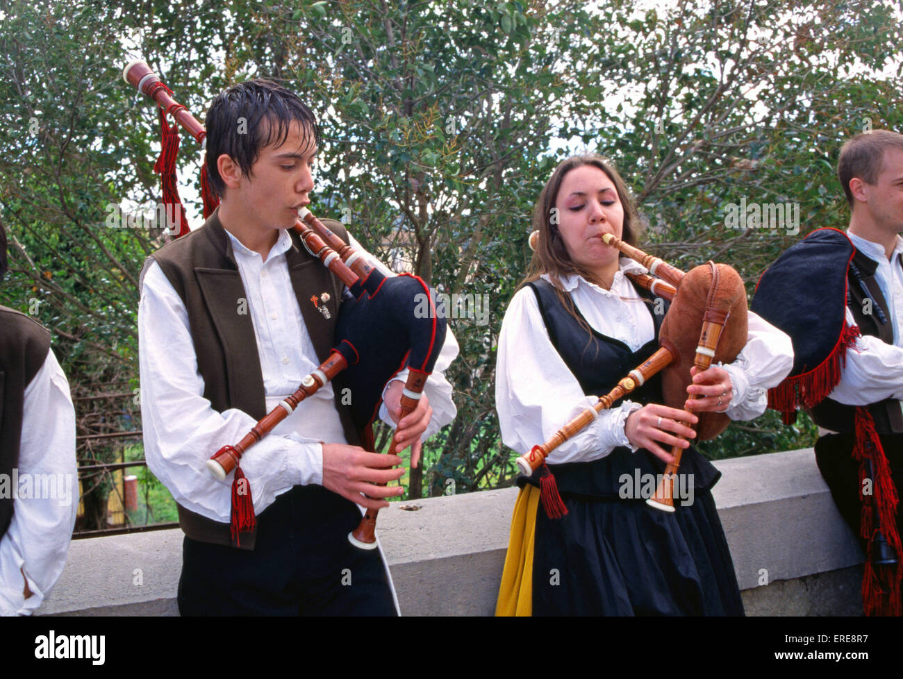 Two young Galician bagpipe players (male and female) performing in