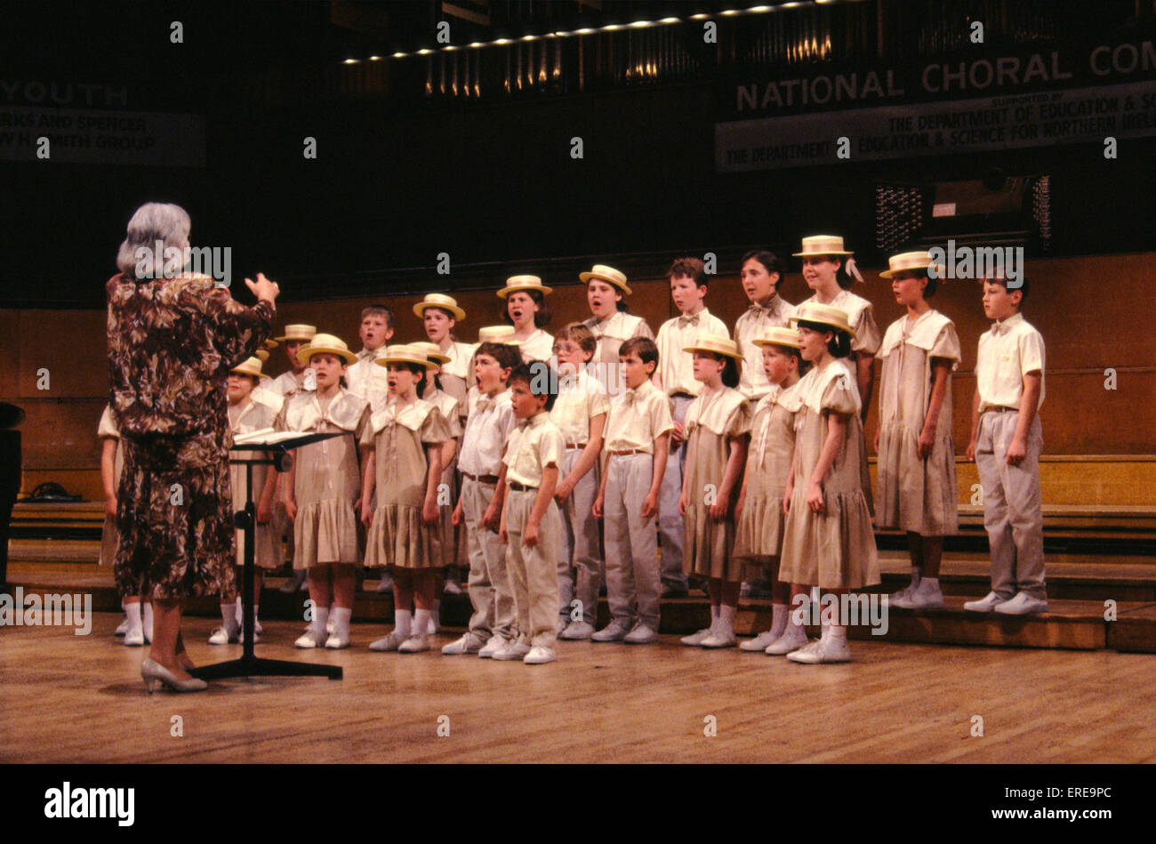 Children 's choir performing singing (mouths open).  Wearing hats. Hat Stock Photo