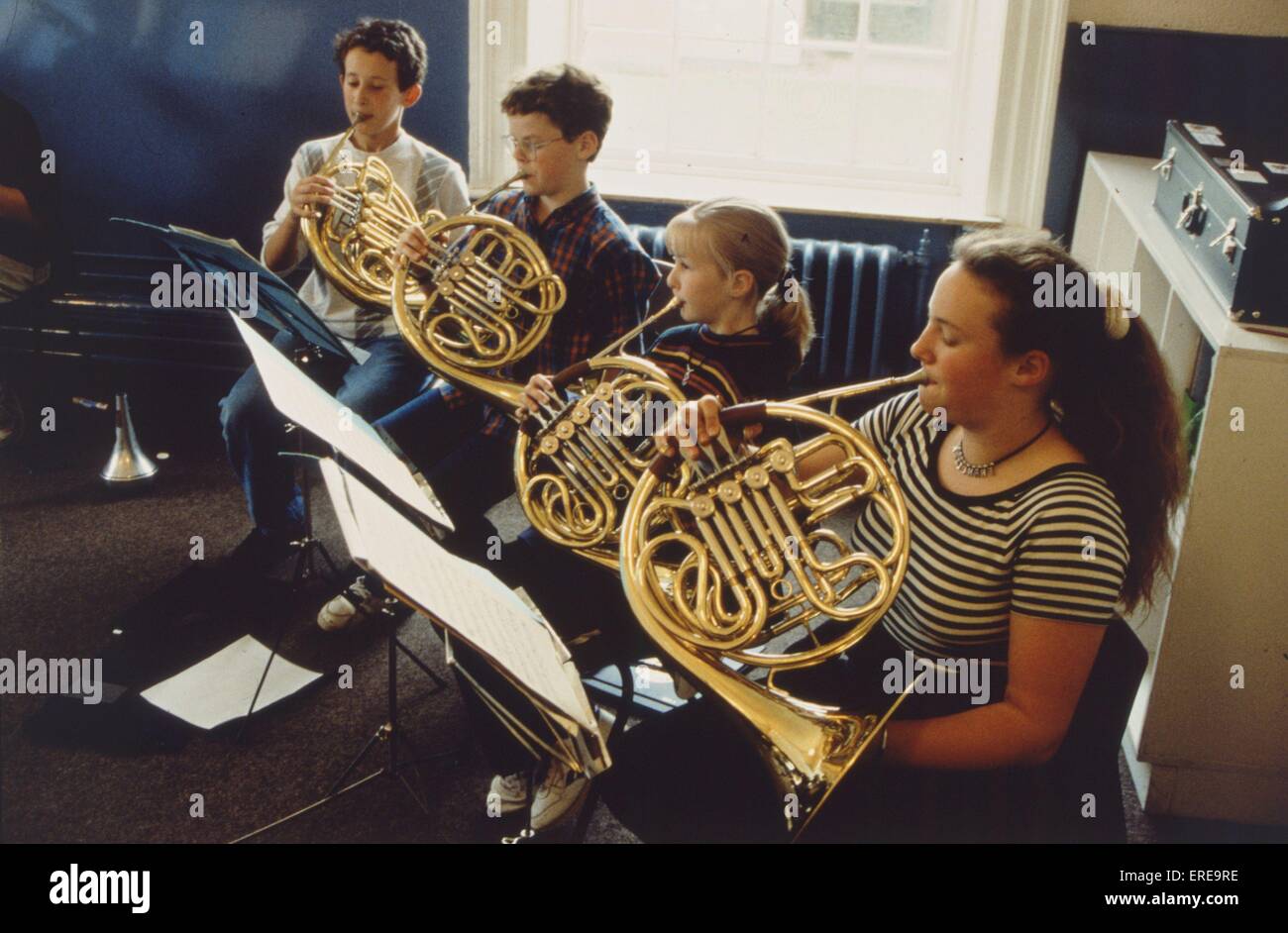 Children, young people playing french horn, reading scores Stock Photo