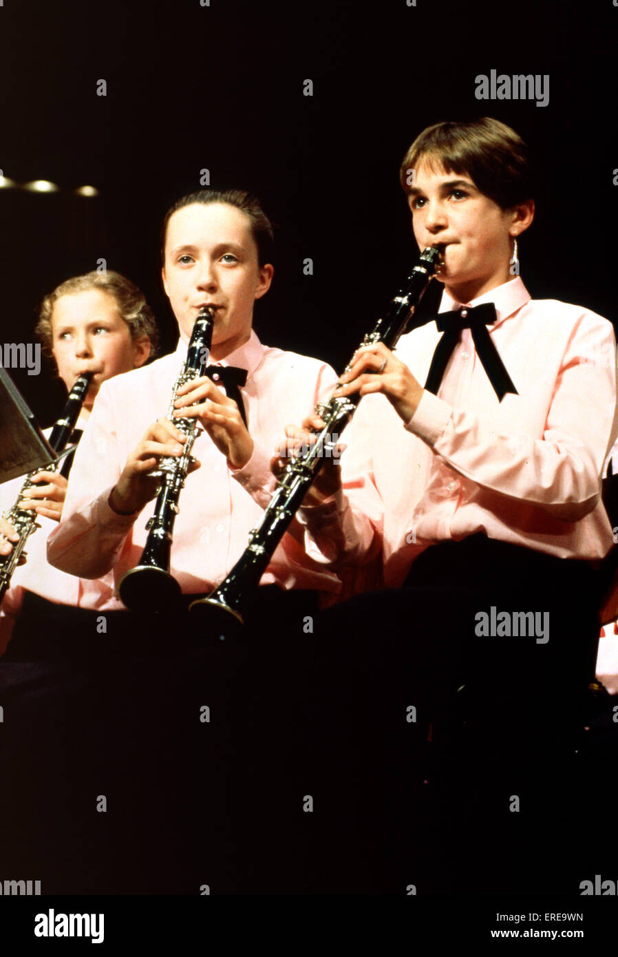 Boys playing clarinet in youth orchestra all wearing same shirts. Stock Photo