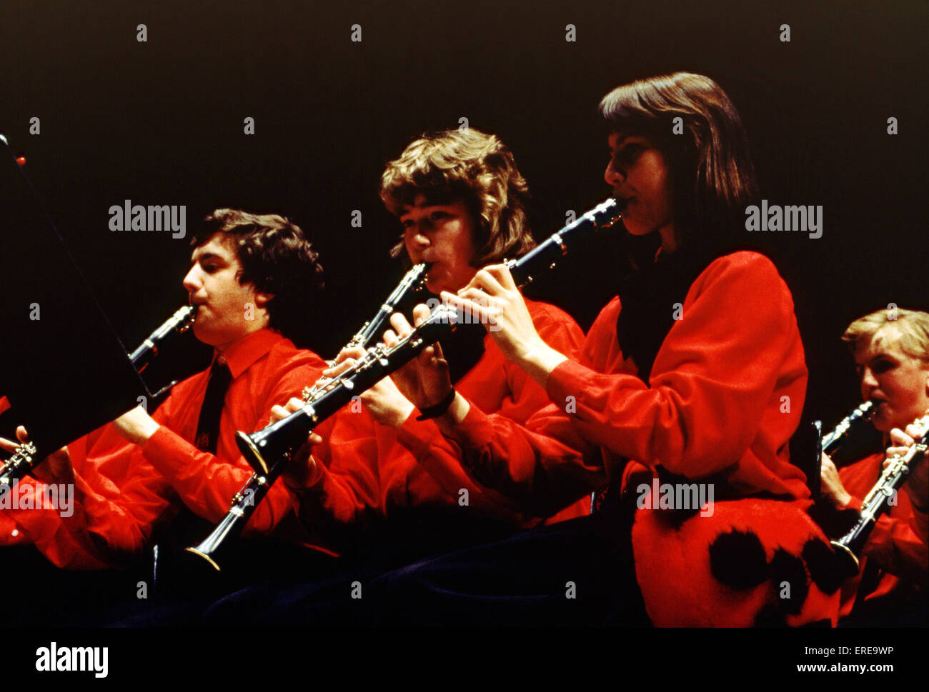 Girls playing clarinet in youth orchestra. all wearing red sweaters Stock Photo