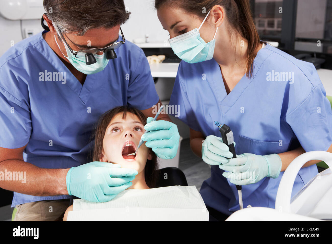 Dentist And Nurse Giving Girl Check Up Stock Photo
