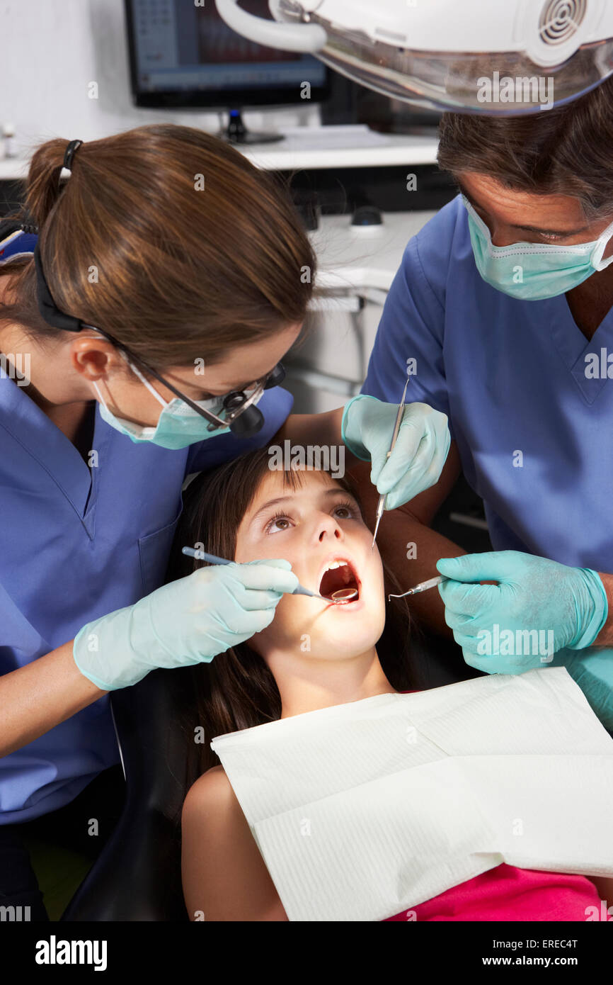 Dentist And Nurse Giving Girl Check Up Stock Photo