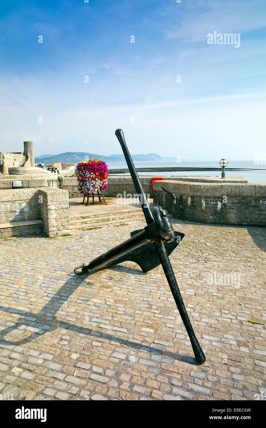 A reclaimed ships anchor and floral display on the seafront in Lyme Regis on the Jurassic Coast, Dorset, England, UK Stock Photo