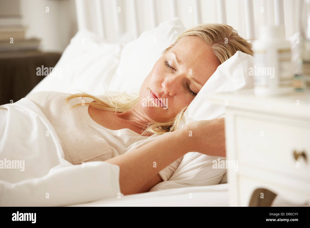 Medication On Bedside Table Of Sleeping Woman Stock Photo