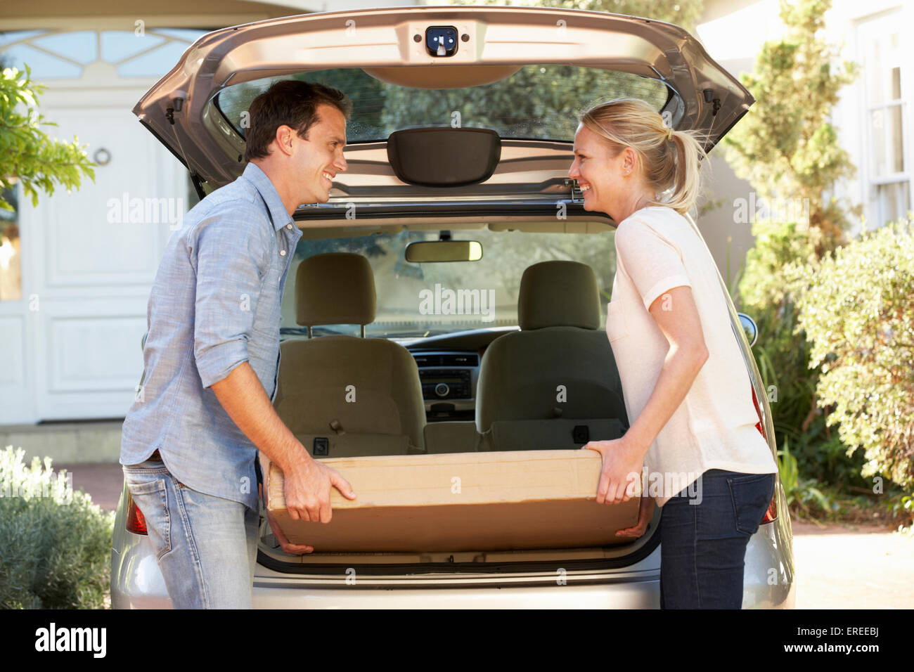 Couple Loading Large Package Into Back Of Car Stock Photo