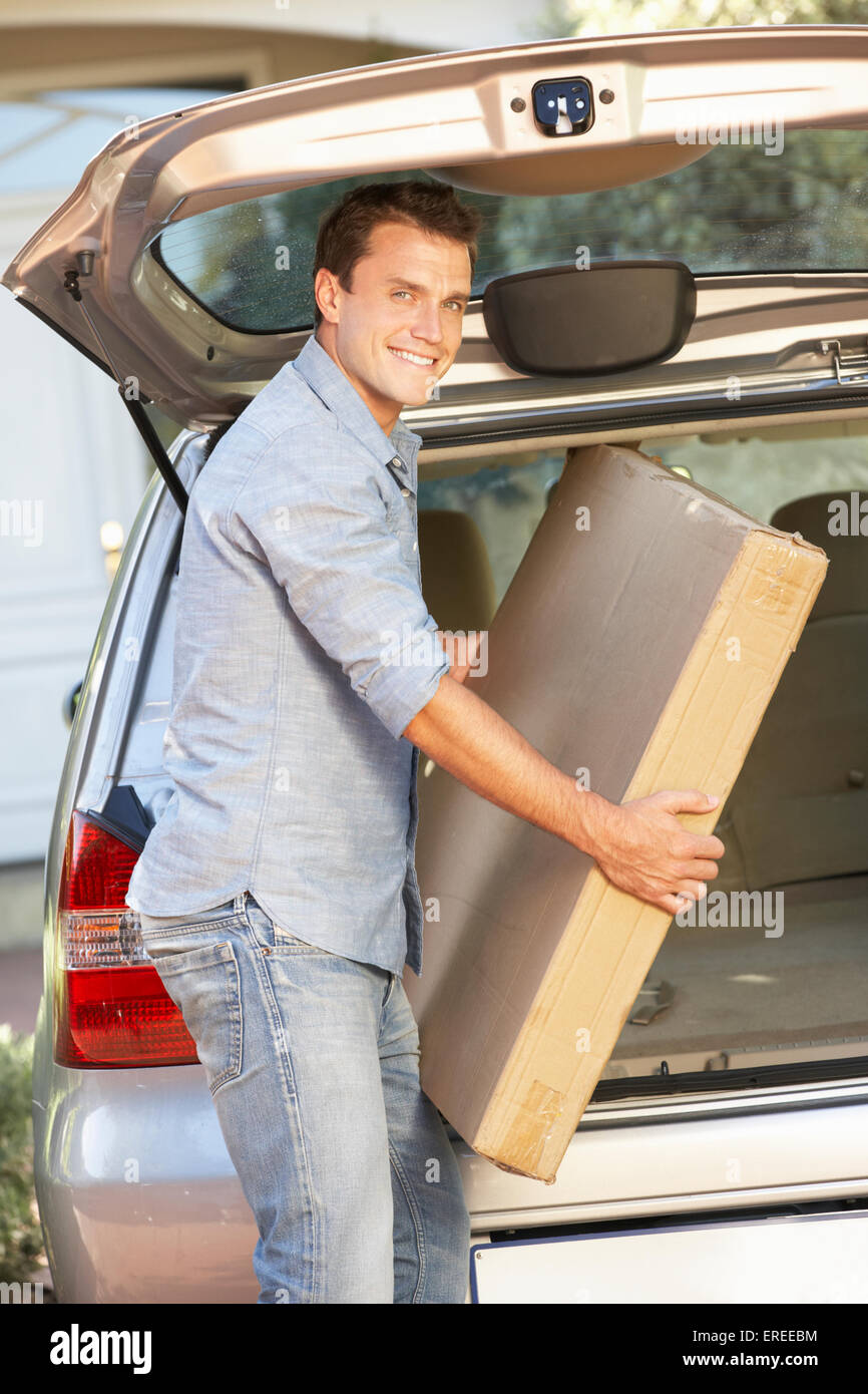 Man Loading Large Package Into Back Of Car Stock Photo