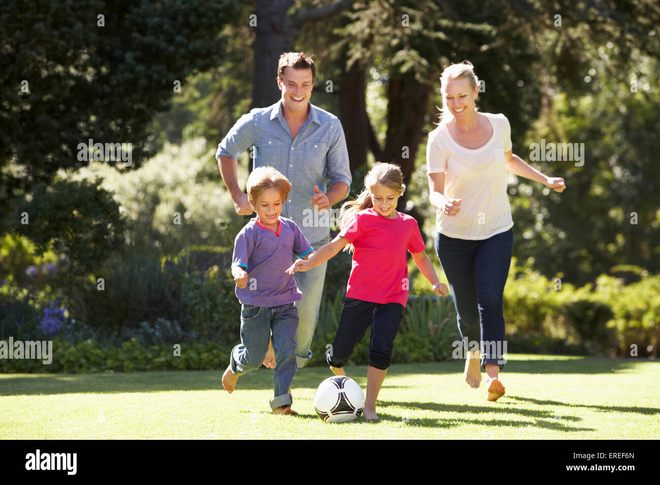 Family Playing Football In Garden Together Stock Photo - Alamy