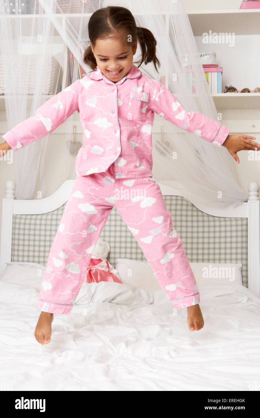 Young Girl Wearing Pajamas Jumping On Bed Stock Photo Alamy