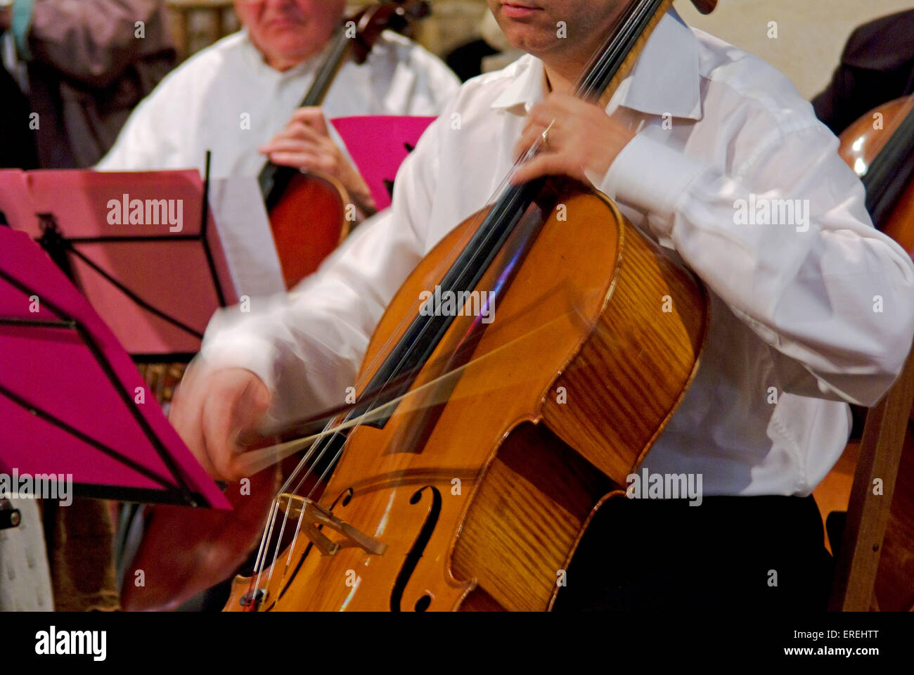 Close-up of cellist's hands in action, showing the vibrato movement of the left hand as well as the movement of the bow. Stock Photo