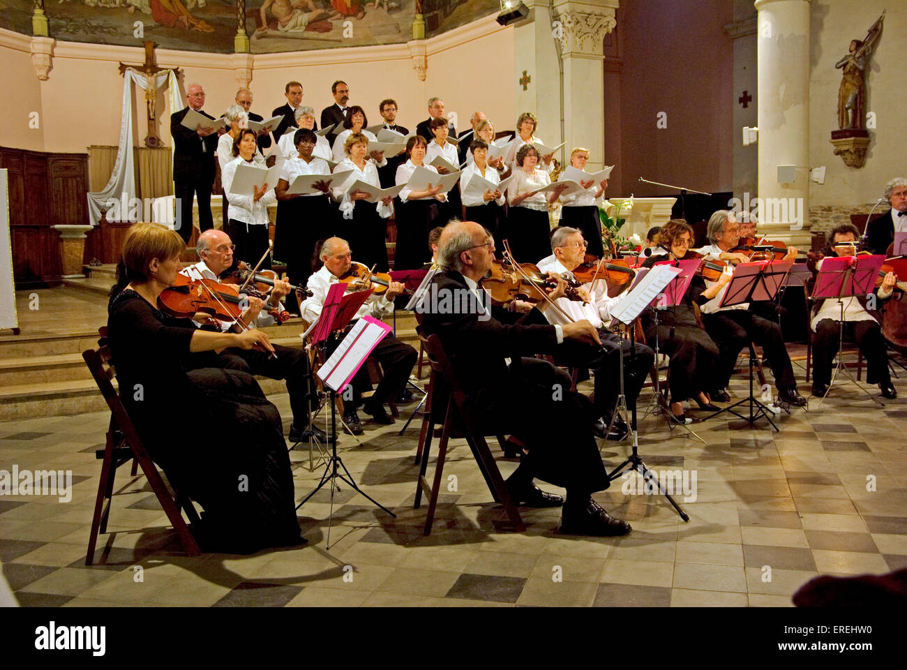 Adult choir and chamber orchestra, performing in the church of Marguerittes, a village close to Nîmes, in southern France. Led Stock Photo