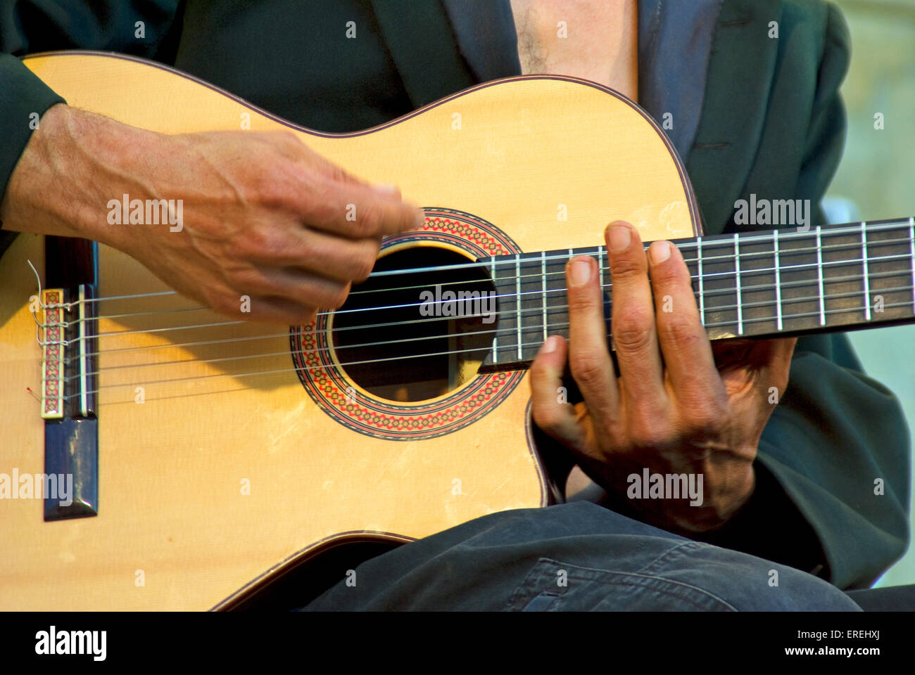 Closeup of acoustic guitarist's hands, showing the strumming movement