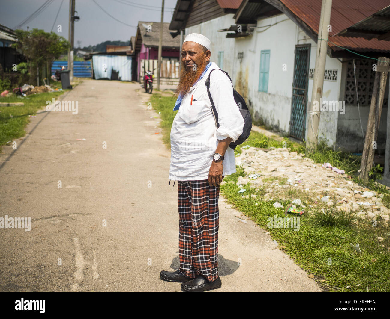 June 1, 2015 - Kulai, Johore, Malaysia - MOHAMED SHAFI bin HABE, a prominent member of the Rohingya community in Kulai, Malaysia, walks through a neighborhood that houses more than 100 Rohingya refugees in Kulai. The UN says the Rohingya, a Muslim minority in western Myanmar, are the most persecuted ethnic minority in the world. The government of Myanmar insists the Rohingya are illegal immigrants from Bangladesh and has refused to grant them citizenship. Most of the Rohingya in Myanmar have been confined to Internal Displaced Persons camp in Rakhine state, bordering Bangladesh. © ZUMA Press,  Stock Photo